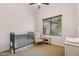 Cozy bedroom with a rocking chair, crib, and neutral color scheme at 7915 E Stonecliff Cir, Mesa, AZ 85207