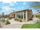 Stunning backyard view of the house with a manicured lawn, patio, and desert landscaping at 7915 E Stonecliff Cir, Mesa, AZ 85207