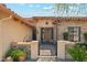 Close-up of a stone and stucco entrance with an iron gate and a decorative wooden front door at 7915 E Stonecliff Cir, Mesa, AZ 85207