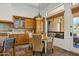 Charming eat-in kitchen featuring wood cabinets, stone tile flooring, and sunny breakfast nook at 7915 E Stonecliff Cir, Mesa, AZ 85207