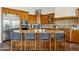 Large kitchen island with granite countertops, bar seating, and custom wood cabinetry at 7915 E Stonecliff Cir, Mesa, AZ 85207