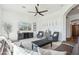 Bright living room featuring neutral decor, large windows, and a stylish ceiling fan at 7915 E Stonecliff Cir, Mesa, AZ 85207