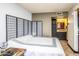 Primary bedroom featuring ensuite bath, ample natural light, dark laminate flooring, and neutral paint at 8155 E Roosevelt St # 231, Scottsdale, AZ 85257