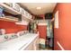 Laundry room with washer and dryer, white wire rack shelving, and red accent wall at 8155 E Roosevelt St # 231, Scottsdale, AZ 85257