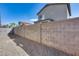 Backyard enclosed by a concrete block wall with gravel ground cover and view of the house at 849 E Impreria St, San Tan Valley, AZ 85140