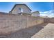 Backyard enclosed by a concrete block wall with gravel ground cover and view of the house at 849 E Impreria St, San Tan Valley, AZ 85140