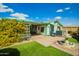 Well-maintained backyard with artificial grass, a paver patio, decorative fountain, and covered porch area at 8500 E Southern Ave # 447, Mesa, AZ 85209