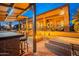 Stunning outdoor living space with a covered kitchen, bar, cozy fire pit, and ample seating at 8541 E Canyon Estates Cir, Gold Canyon, AZ 85118
