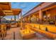 Outdoor oasis with a fully equipped kitchen, bar, built-in seating, and a charming fire pit at 8541 E Canyon Estates Cir, Gold Canyon, AZ 85118