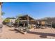 Entertainer's backyard featuring a built-in grill under a shaded pergola, surrounded by desert landscaping at 8541 E Canyon Estates Cir, Gold Canyon, AZ 85118