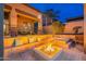 This backyard paradise offers a modern fire pit with built-in seating and lush landscaping for ultimate relaxation at 8541 E Canyon Estates Cir, Gold Canyon, AZ 85118