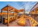 Entertainer's backyard featuring a covered outdoor kitchen, bar seating, and a warm fire pit at 8541 E Canyon Estates Cir, Gold Canyon, AZ 85118
