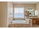 Bathroom featuring a soaking tub with decorative tile and a window with sheer curtains at 8541 E Canyon Estates Cir, Gold Canyon, AZ 85118