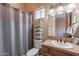 Bathroom featuring tiled vanity, decorative mirror, shower with curtain, and toilet at 8541 E Canyon Estates Cir, Gold Canyon, AZ 85118