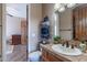 Bathroom features wood vanity, sink, mirror, stacked towels, and an open door at 8541 E Canyon Estates Cir, Gold Canyon, AZ 85118
