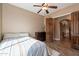 Cozy bedroom with hardwood floors, ceiling fan, and views into arched hallway at 8541 E Canyon Estates Cir, Gold Canyon, AZ 85118