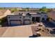 Aerial view of the exterior showcasing its three car garage and desert landscaping at 8541 E Canyon Estates Cir, Gold Canyon, AZ 85118