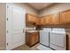 A functional laundry room with modern washer and dryer, sink, and ample cabinet space at 8541 E Canyon Estates Cir, Gold Canyon, AZ 85118