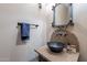 Powder room boasting decorative mirror and dark copper sink with a stone countertop at 8541 E Canyon Estates Cir, Gold Canyon, AZ 85118
