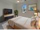 Relaxing bedroom features a large window, ceiling fan and a modern accent cabinet at 9327 E Static Ave, Mesa, AZ 85212
