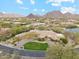 An aerial view of a desert property showcasing mountain views and a circular driveway at 9513 N 129Th Pl, Scottsdale, AZ 85259