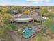 Drone image showcasing the backyard of a desert estate with a private pool, spa, and covered patio at 9513 N 129Th Pl, Scottsdale, AZ 85259