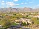 Desert home boasts lush green lawn, circular driveway, flowering bushes, and a gorgeous mountain view at 9513 N 129Th Pl, Scottsdale, AZ 85259