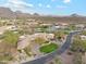 Expansive desert home showcasing lush landscaping, circular driveway, and picturesque mountain views at 9513 N 129Th Pl, Scottsdale, AZ 85259