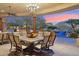 Outdoor dining area features elegant seating, stone columns, and scenic views of the pool and mountains at 9513 N 129Th Pl, Scottsdale, AZ 85259