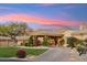 Stunning home with desert landscaping, a circular driveway, and porte-cochere with a beautiful sunset backdrop at 9513 N 129Th Pl, Scottsdale, AZ 85259