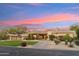 Stunning home with desert landscaping, a circular driveway, and porte-cochere with a beautiful sunset backdrop at 9513 N 129Th Pl, Scottsdale, AZ 85259