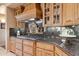Stylish kitchen with granite countertops, custom cabinets, and a gas cooktop with decorative backsplash at 9513 N 129Th Pl, Scottsdale, AZ 85259