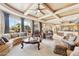 Open living room with views of the kitchen, featuring coffered ceilings and comfortable seating arrangements at 9513 N 129Th Pl, Scottsdale, AZ 85259