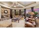 Elegant living room with a stone fireplace, large windows offering scenic views, and comfortable seating at 9513 N 129Th Pl, Scottsdale, AZ 85259