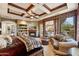 Spacious main bedroom with coffered ceilings, fireplace, seating area, and exterior views at 9513 N 129Th Pl, Scottsdale, AZ 85259