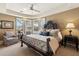 Sunlit main bedroom featuring bay windows, comfortable seating, and a designer headboard at 9513 N 129Th Pl, Scottsdale, AZ 85259