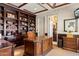 Home office with custom built-in bookshelves, coffered ceiling, and a large wooden desk at 9513 N 129Th Pl, Scottsdale, AZ 85259