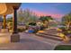Elegant outdoor space with a pool featuring a rock waterfall, lush landscaping, and a multi-level patio at 9513 N 129Th Pl, Scottsdale, AZ 85259