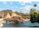 Inviting pool with rock waterfall feature, surrounded by desert landscape and mountain views at 9513 N 129Th Pl, Scottsdale, AZ 85259