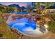 Stunning pool with rock waterfall feature, lush landscaping, and serene mountain views creating a backyard oasis at 9513 N 129Th Pl, Scottsdale, AZ 85259