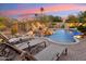 Beautiful pool with a rock waterfall feature and lounge chairs on the brick patio for relaxation at 9513 N 129Th Pl, Scottsdale, AZ 85259