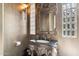 Intricately designed powder room with an ornate mirror and unique glass block window at 9513 N 129Th Pl, Scottsdale, AZ 85259