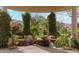 Unique backyard water feature with rock formations, lush greenery, and brick paving creating a peaceful retreat at 9513 N 129Th Pl, Scottsdale, AZ 85259