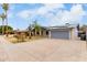 Brick home with a large driveway, gray garage door, and solar panels on the roof at 10009 N 36Th Ave, Phoenix, AZ 85051