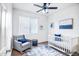 Cozy bedroom with a rocking chair, crib, and blue accents, perfect for a Bedroom at 11729 W Maui Ln, El Mirage, AZ 85335