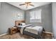Cozy bedroom with a ceiling fan, window, and a small nightstand at 11729 W Maui Ln, El Mirage, AZ 85335