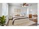 Serene main bedroom with a ceiling fan, plush bedding, and an en-suite bathroom at 11729 W Maui Ln, El Mirage, AZ 85335