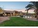 Beautiful backyard with a pool, lush lawn, desert landscaping, and a covered patio at 13126 E Turquoise Ave, Scottsdale, AZ 85259