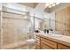 Bathroom featuring glass-enclosed shower, tile surround, and wooden cabinets at 13126 E Turquoise Ave, Scottsdale, AZ 85259