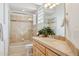 Bright bathroom with tiled shower, tiled counter, and light wood cabinets at 13126 E Turquoise Ave, Scottsdale, AZ 85259